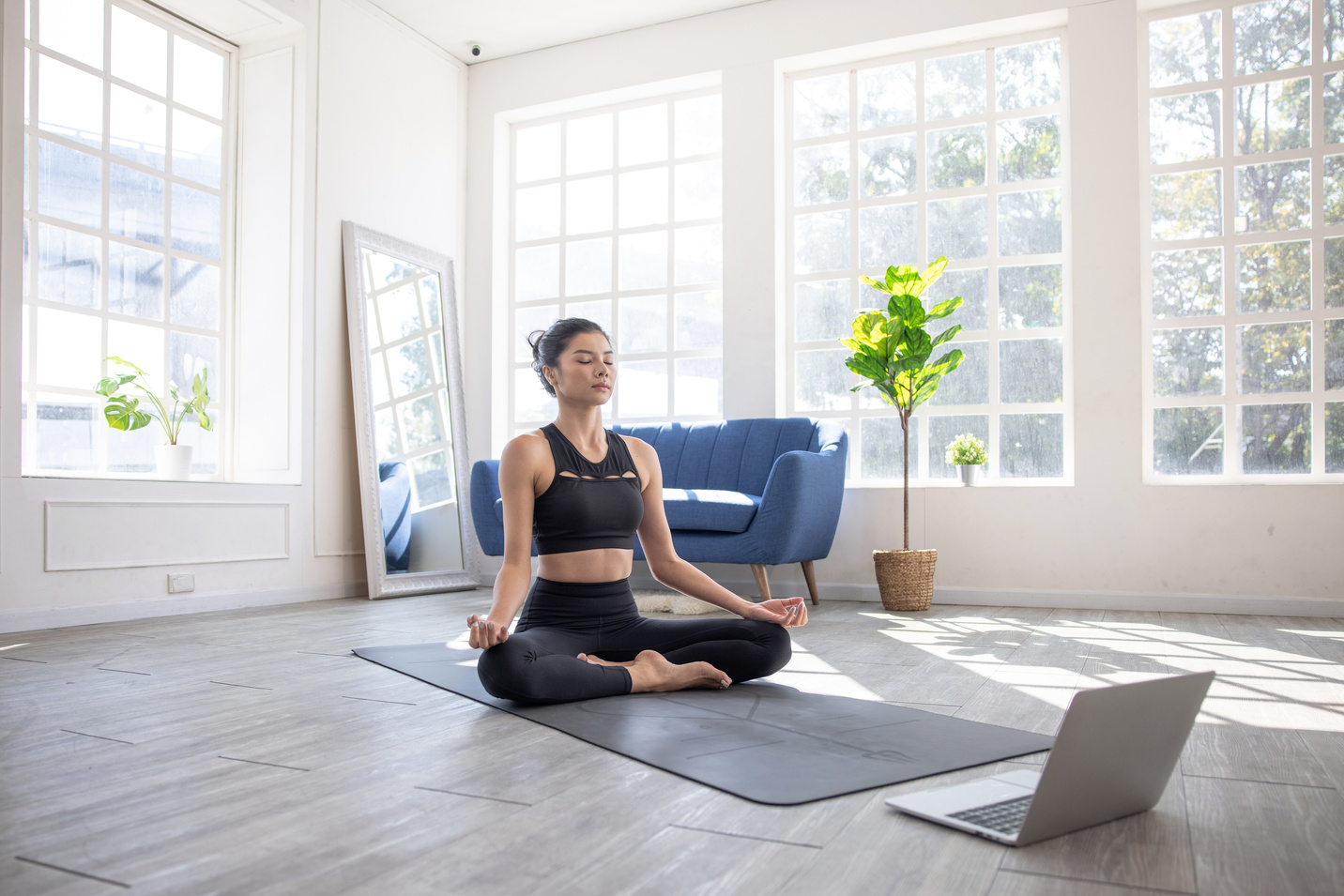 Online yoga instructor, Young Asian woman doing yoga stretching yoga at home.